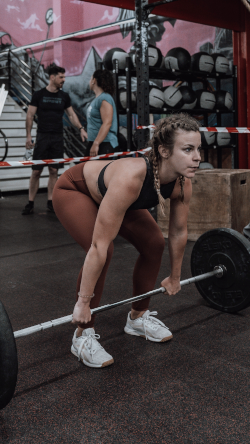 Woman performing a deadlift with a barbell