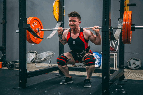 A strong person perfoming a heavy backsquat.