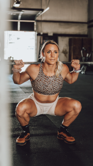 Woman performing a weighted barbell squat.